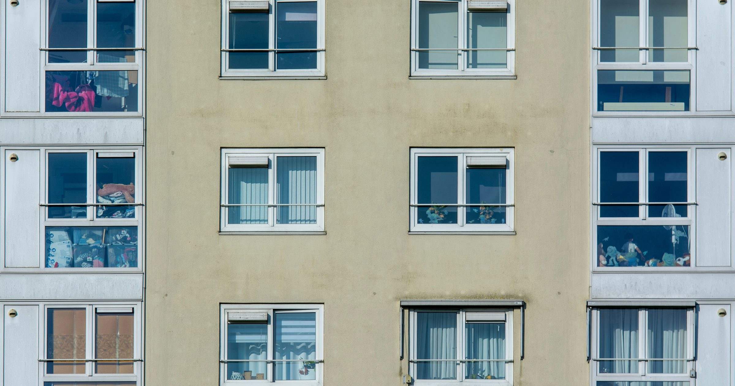 Fațada unui bloc de locuințe, cu ferestre și tâmplărie de apartamente