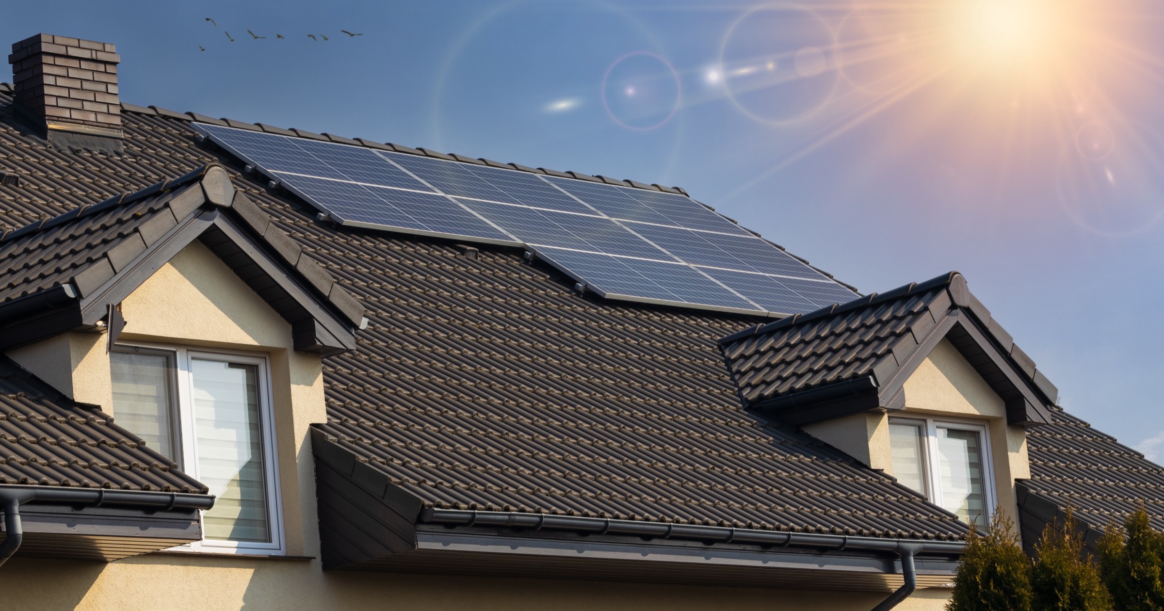 Casă modernă cu panouri fotovoltaice pe acoperiș, sub soare