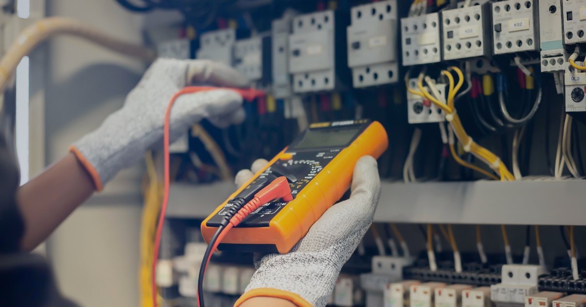Electrician cu aparat de masura conectat la tabloul electric al unei locuinte, verificand priza de pamant si continuitatea instalatiei pentru buletinul PRAM